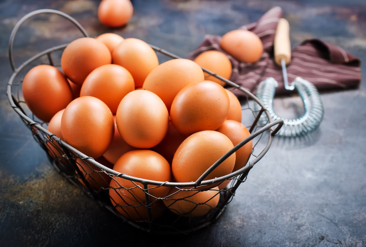 An image of brown eggs in a cylindrical basket.