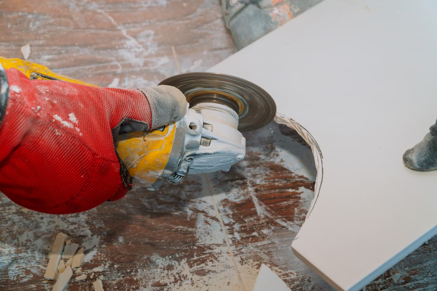 An image of someone cutting tile with a circular saw in a shop.