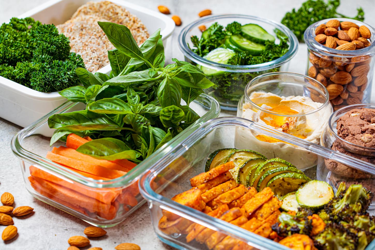 An image of various food containers like Pyrex, plastic, and glass container filled with food.