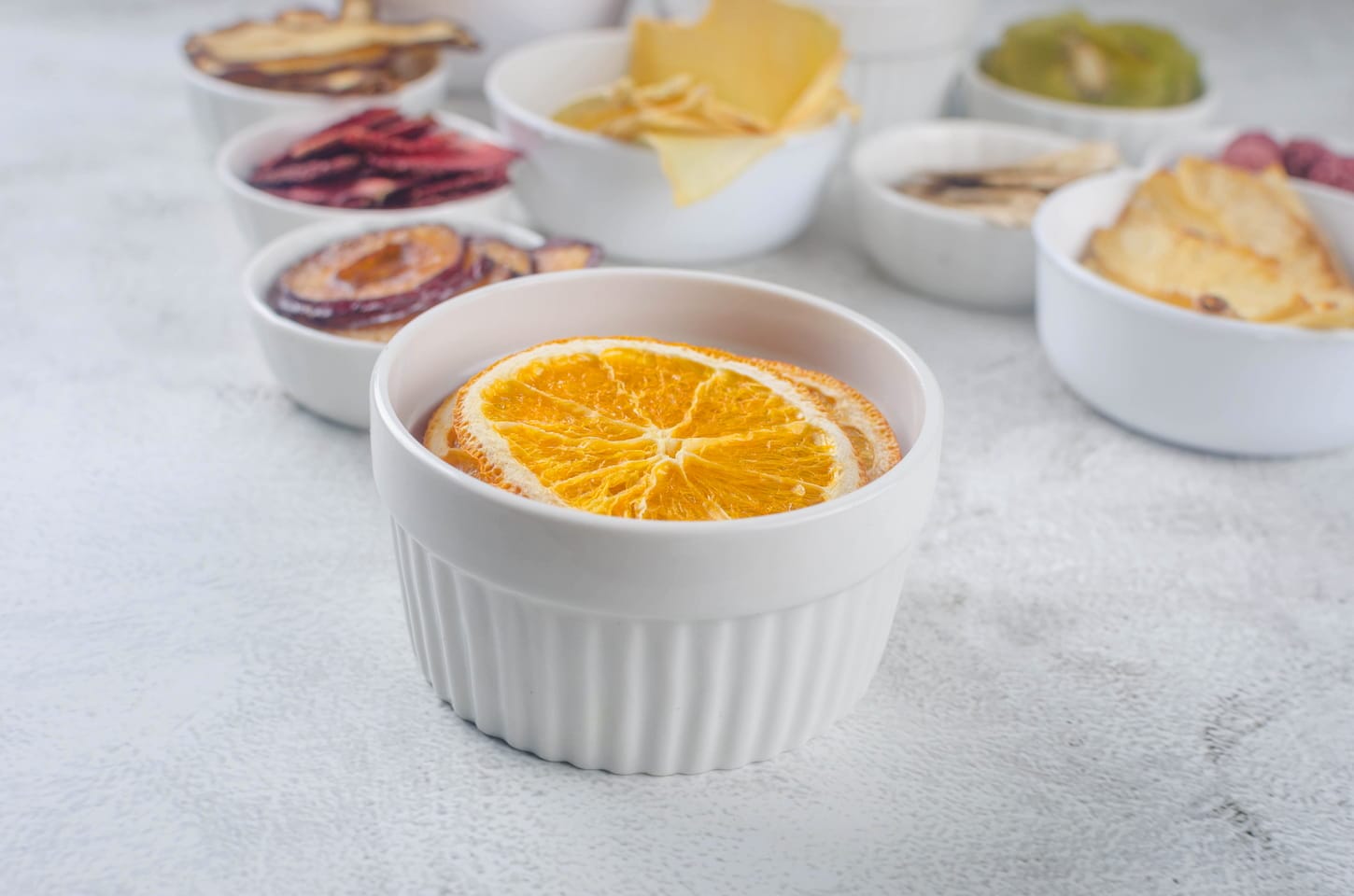An image of assorted ripe fruits and dried chips on grey background.
