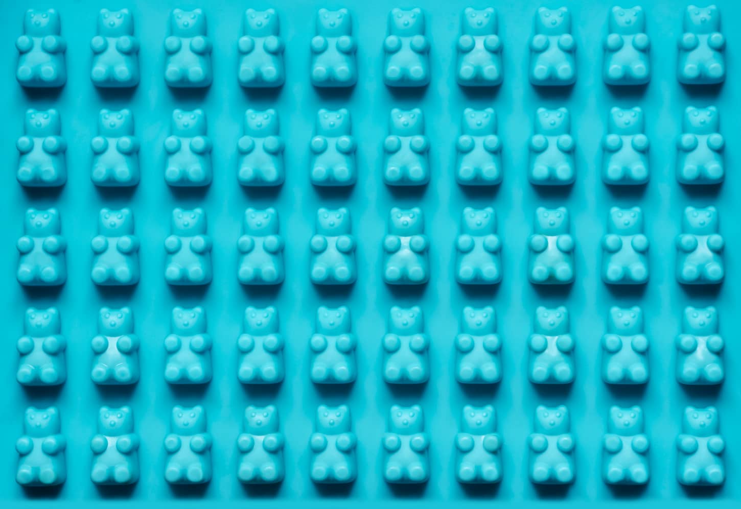 An image of Blue silicone mold texture bear for candies. Candy cup, silicone mold for preparation homemade jelly candy, bakeware.