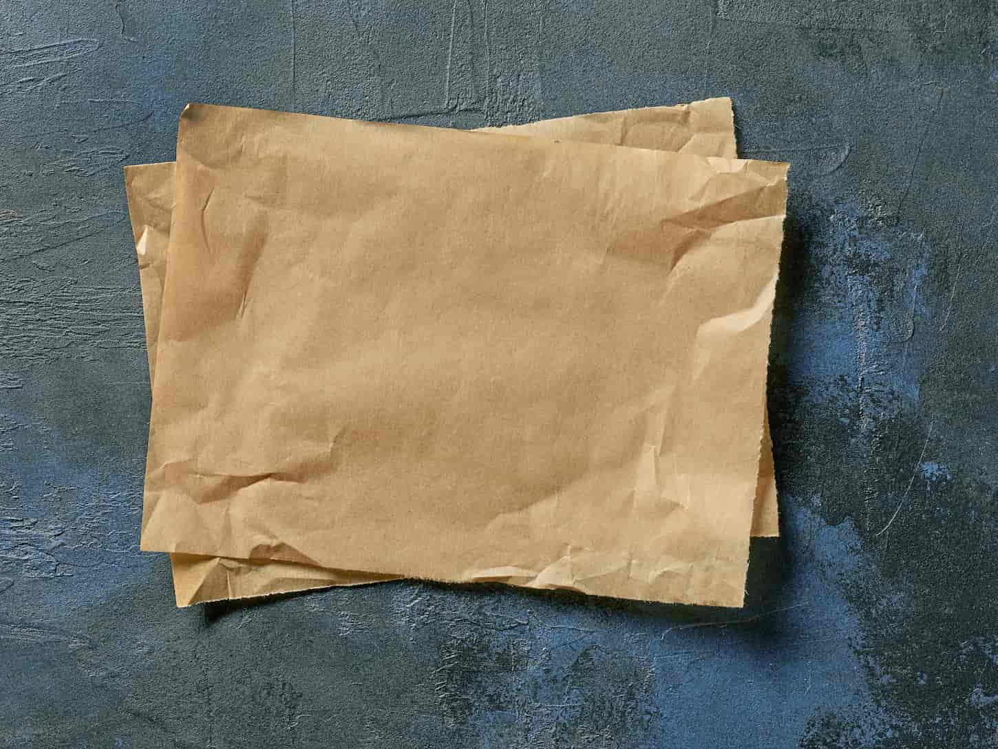 An image of brown baking paper slices on a deep blue painted background.
