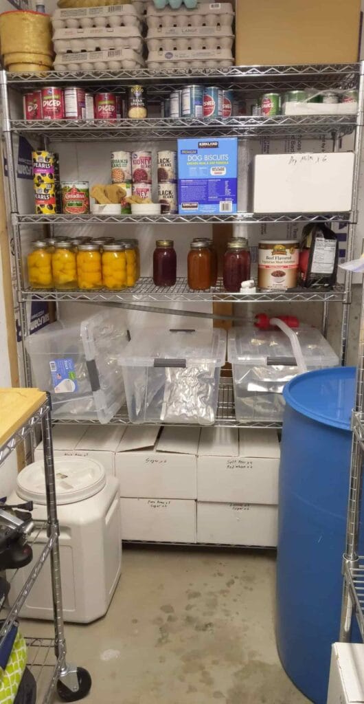 An image of our food storage which includes a 55-gallon water barrel in blue.