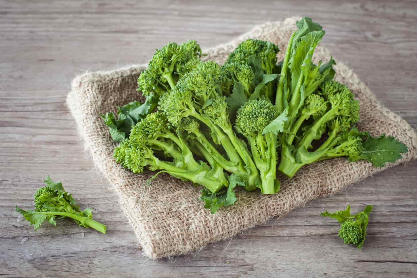 An image of fresh turnip tops on wooden background.