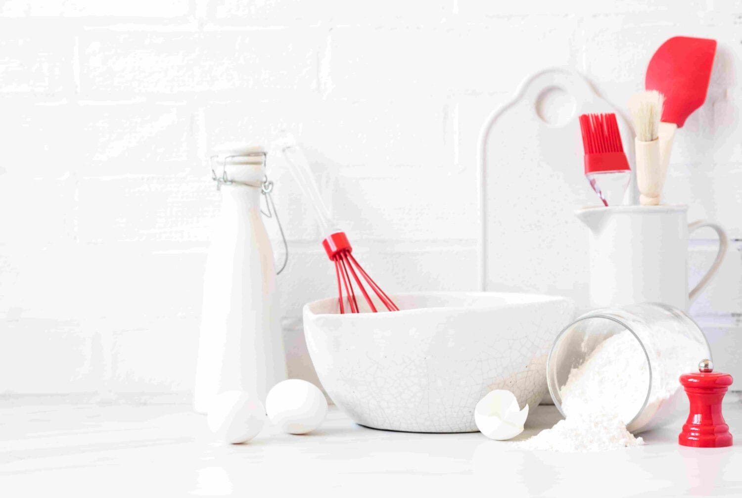 An image of Baking background. Kitchen utensils red white colors Bowls for mixing ingredients. Pancake Products. Flour, milk, eggs.Interior, modern kitchen space in bright colors.