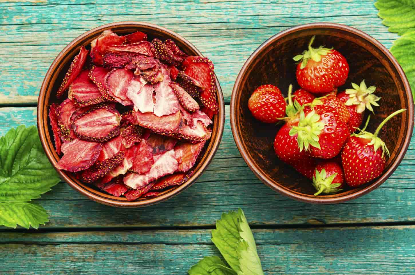 An image of Dried summer berry, fruit dessert. Strawberry chips, and berry sweetness on rustic wooden background.