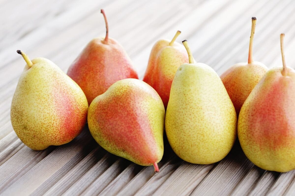An image of ripe pears on a wooden, corrugated type of background.
