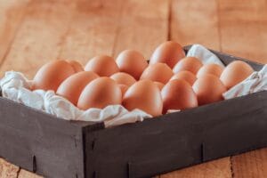 An image of a Black wooden box full of fresh eggs.