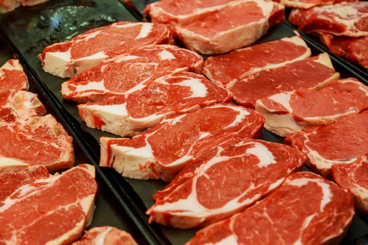 An image of different cuts of fresh raw red meat in a supermarket.